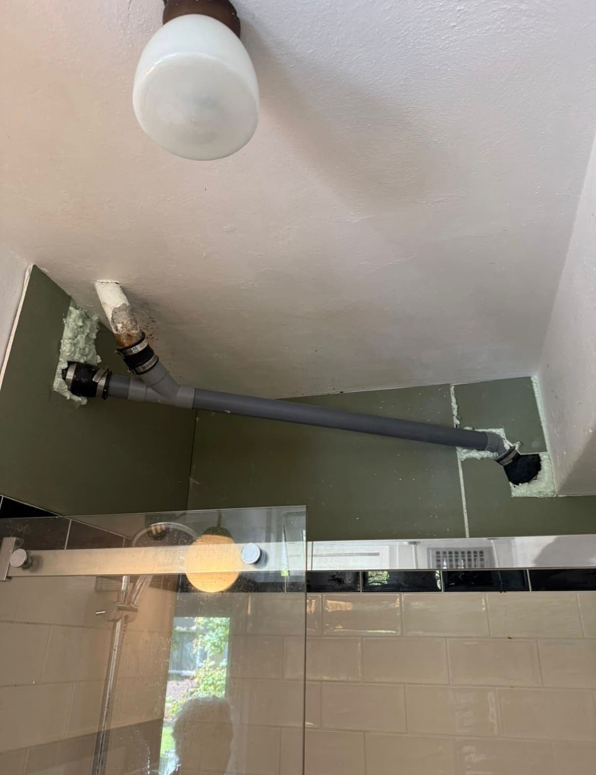 Afvoerleiding in het plafond van een badkamer