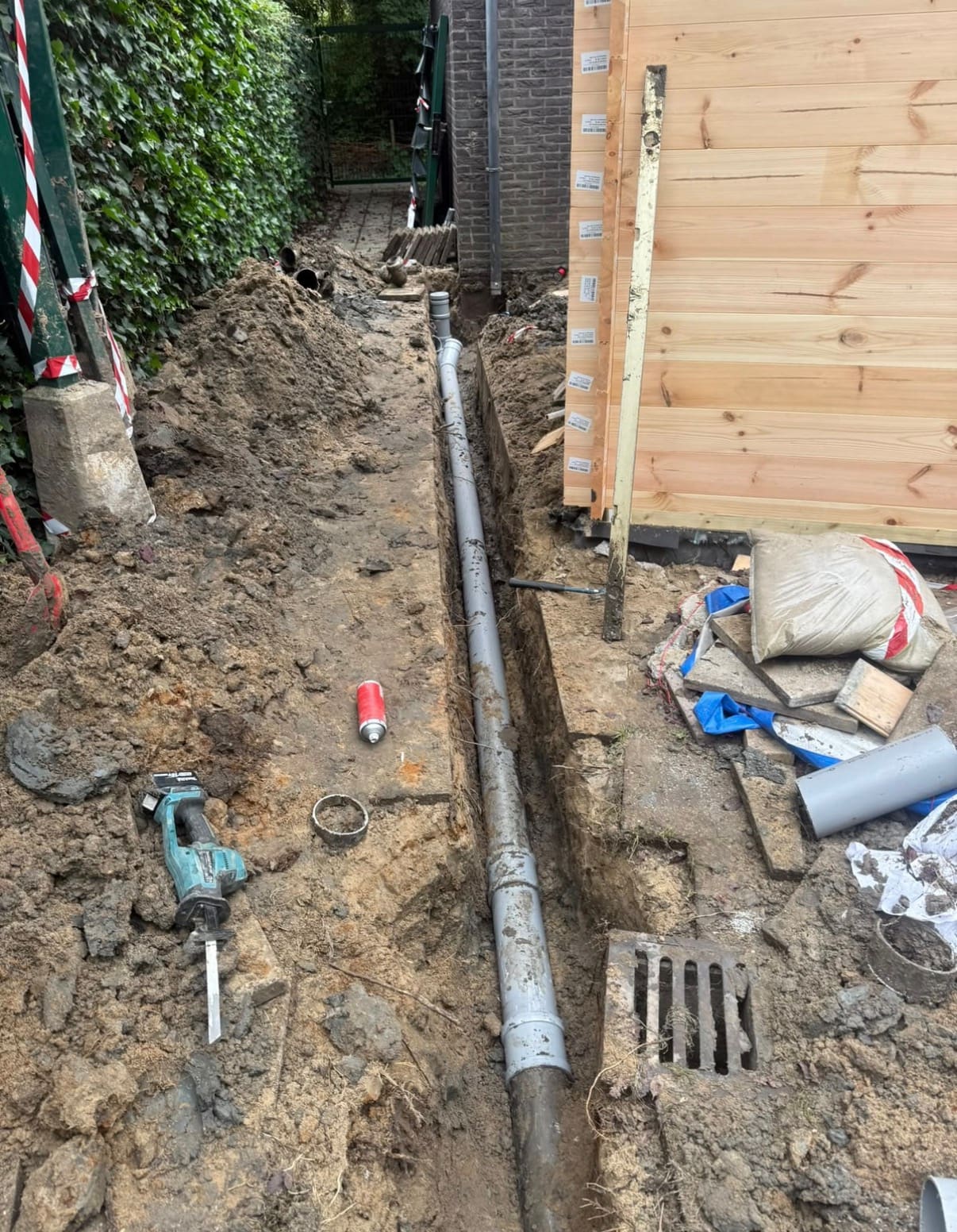 Open sleuf in de tuin met nieuwe rioolbuis